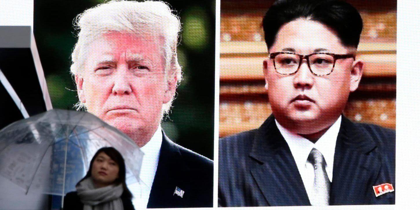 En kvinna i Sydkoreas huvudstad Seoul vid en nyhetsskärm Med bild på USA:s president Donald Trump och Nordkoreas diktator Kim Jong-Un.