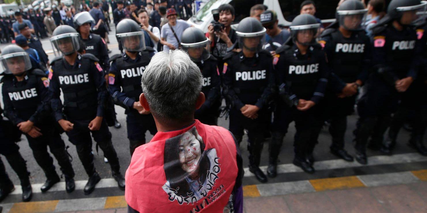 En demonstrant bärande en sjal med en bild på den avsatta premiärministern Yingluck Shinawatra under tisdagens protest i Bangkok i Thailand.