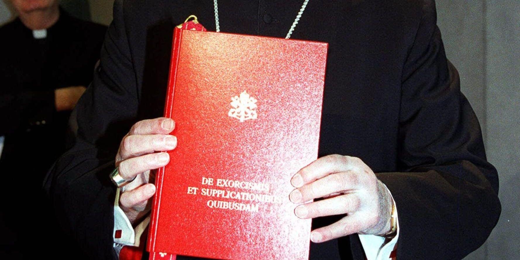 Kardinal Jorge Medina Estévez från Chile håller upp den nya handbok i exorcism som Vatikanen släppte 1999.
