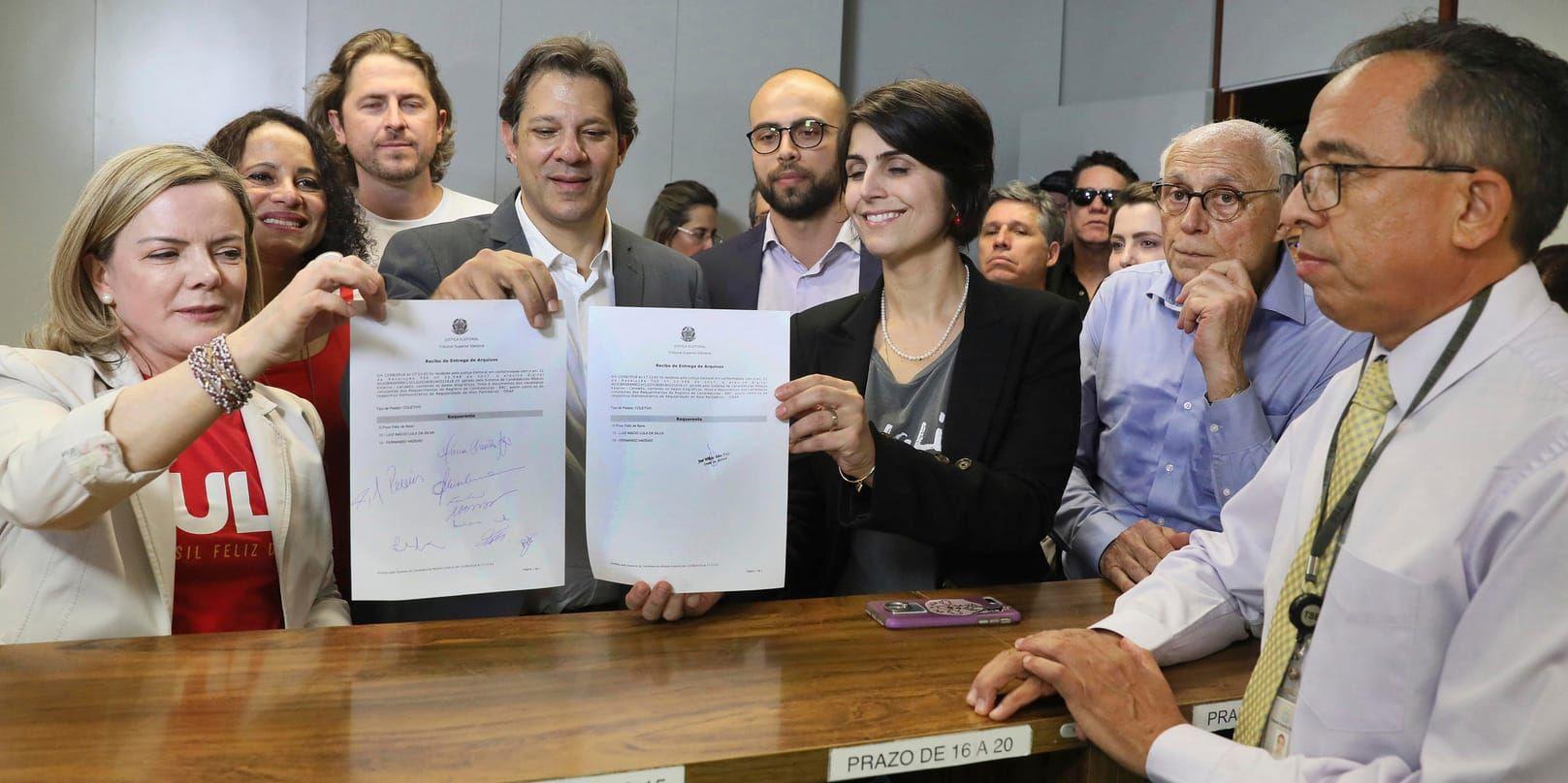 Arbetarpartiets ordförande Gleisi Hoffmann, längst till vänster, visar tillsammans med partivänner upp registreringsdokumenten för presidentkandidaten Lula da Silva på onsdagen.