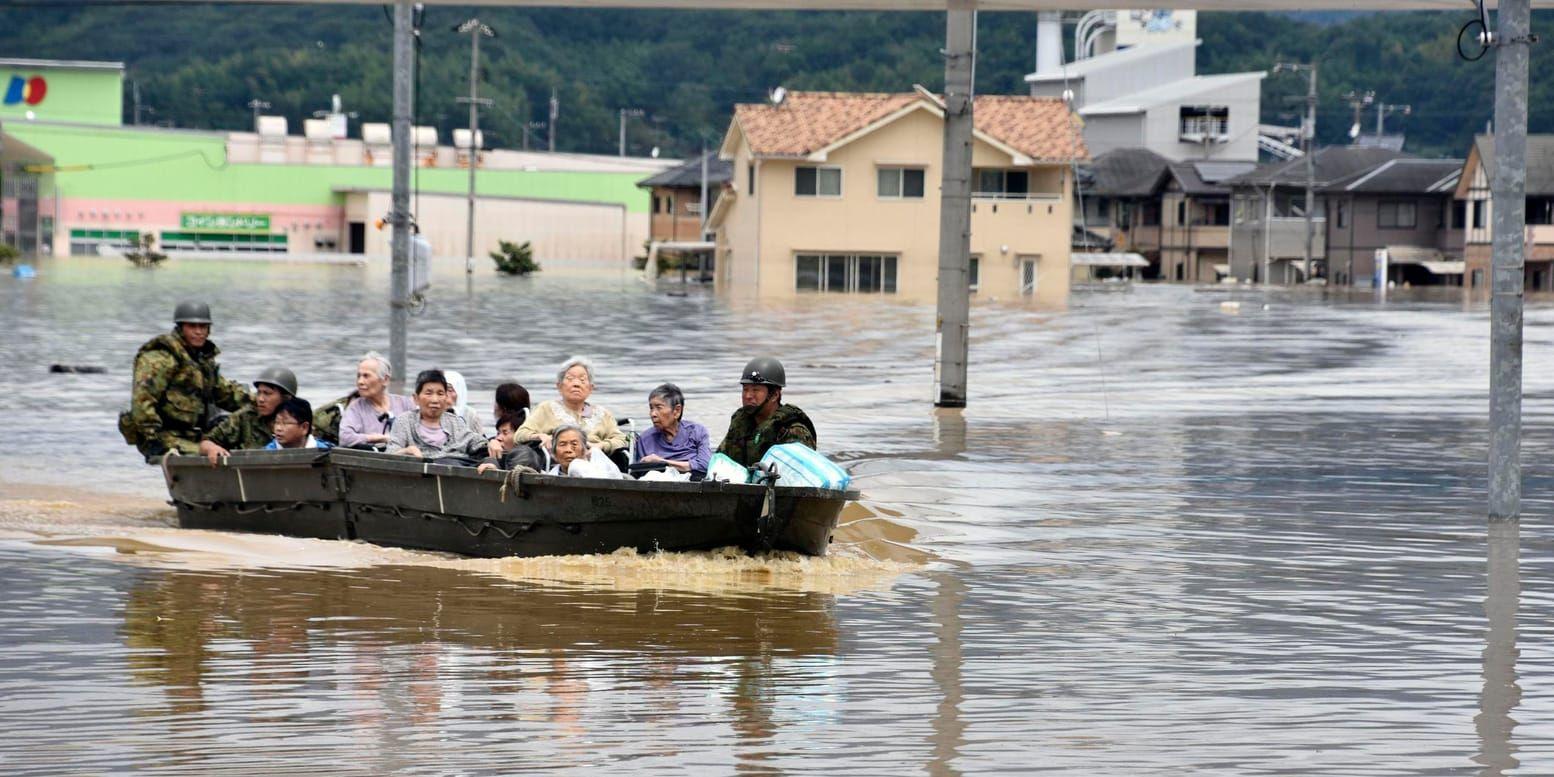 En grupp människor räddas med båt i den översvämmade staden Kurashiki i den västliga prefekturen Okayama.