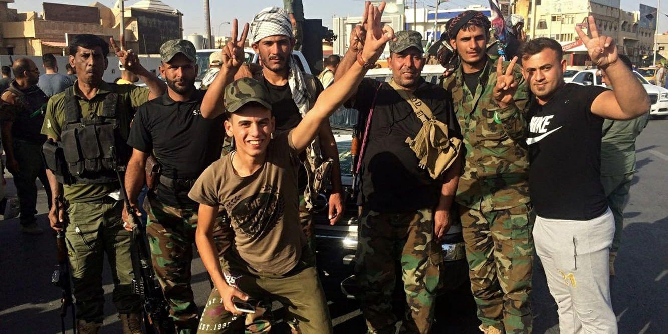 Irakiska soldater firar framför det lokala regeringskansliet i Kirkuk efter att ha tagit kontroll över byggnaden på måndagen.