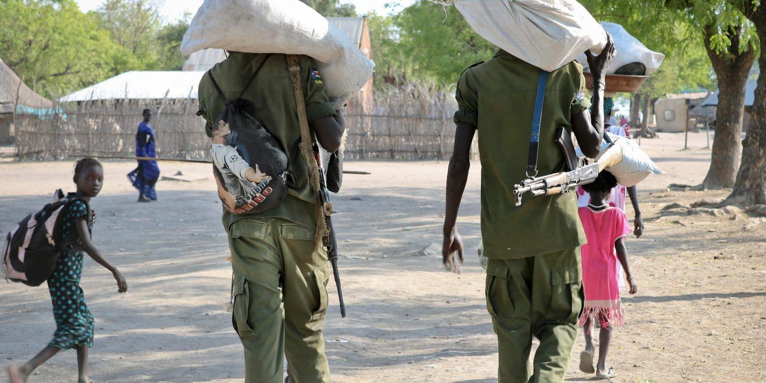 Beväpnade rebeller går längs med gatan i Akobo, nära gränsen till Etiopien. USA förbjuder nu export av försvarsmateriel och försvarstjänster till landet. Arkivbild.