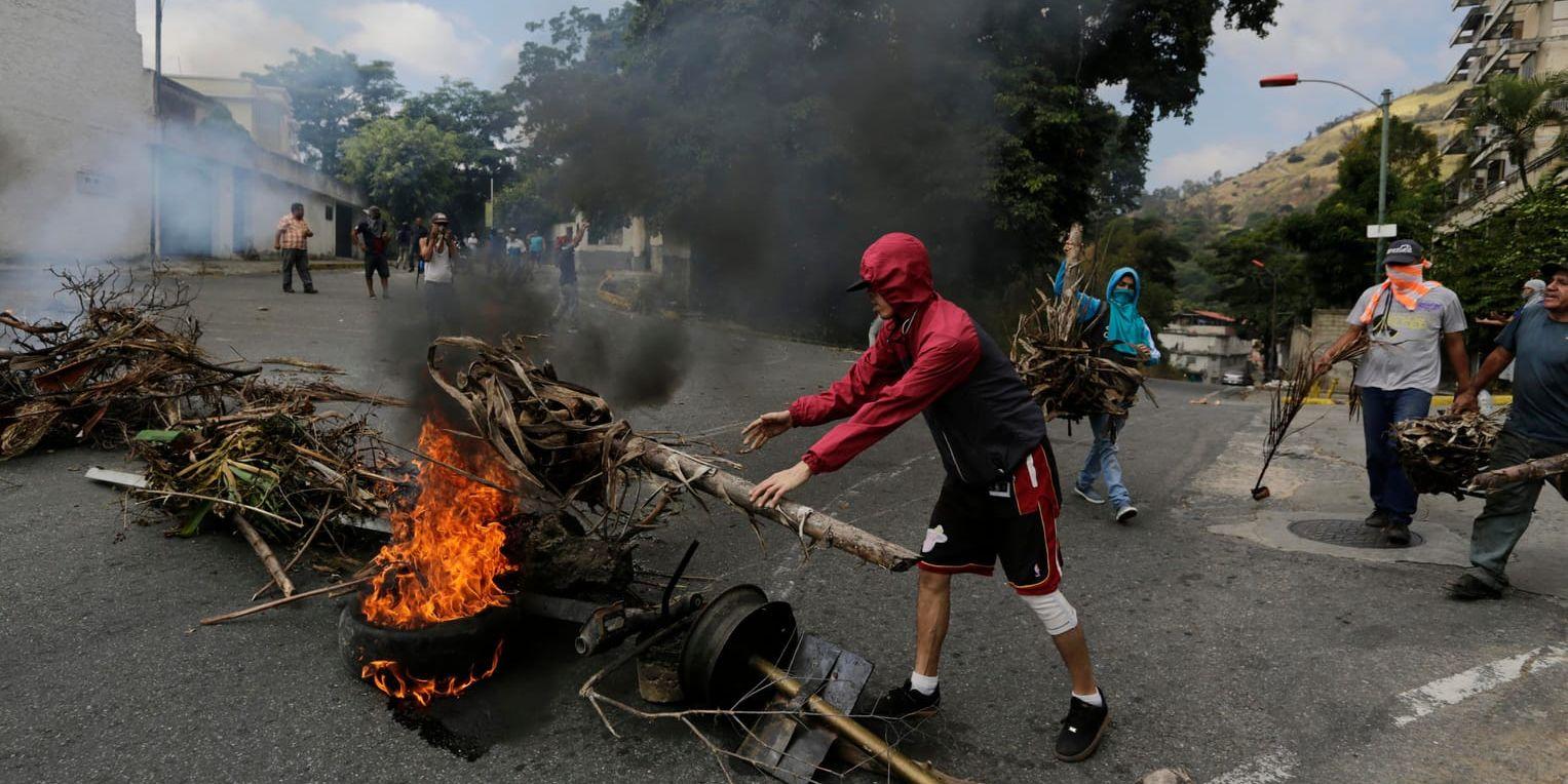 Oppositionsanhängare bygger en brinnande barrikad under sammandrabbningar med säkerhetsstyrkor vid en protest i Caracas-stadsdelen Cotiza till stöd för den grupp militärer som genomförde en kortlivad revolt på måndagen.