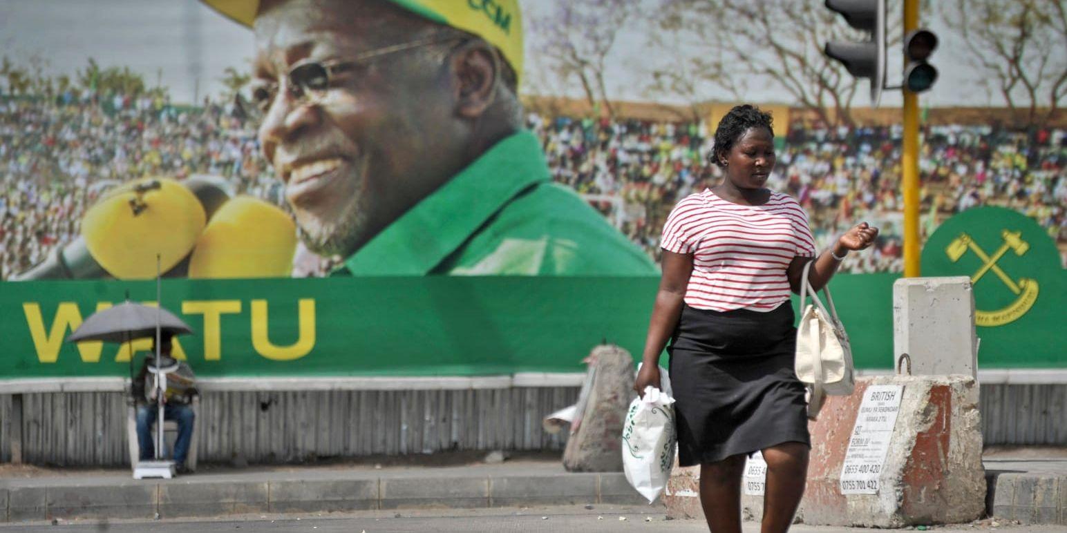 En kvinna framför en affisch av president John Magufuli inför valet 2015. Arkivbild.