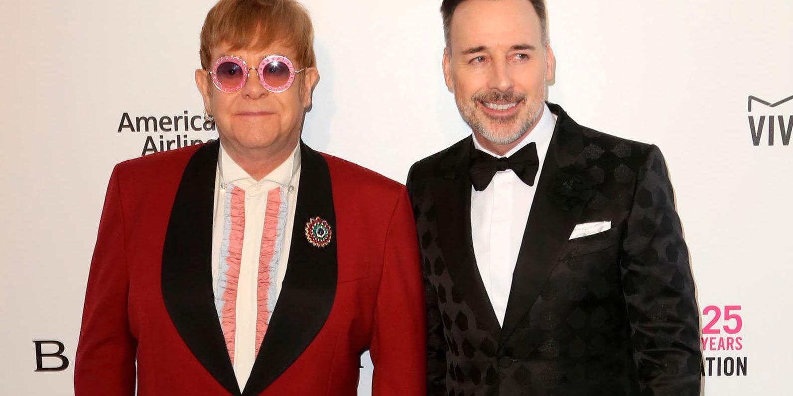 Elton John och hans make David Furnish får skadestånd från brittiska The Sun. Arkivbild.