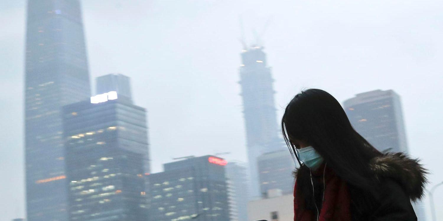 En invånare i Peking bär munskydd för att inte andas in skadliga partiklar. Arkivbild.