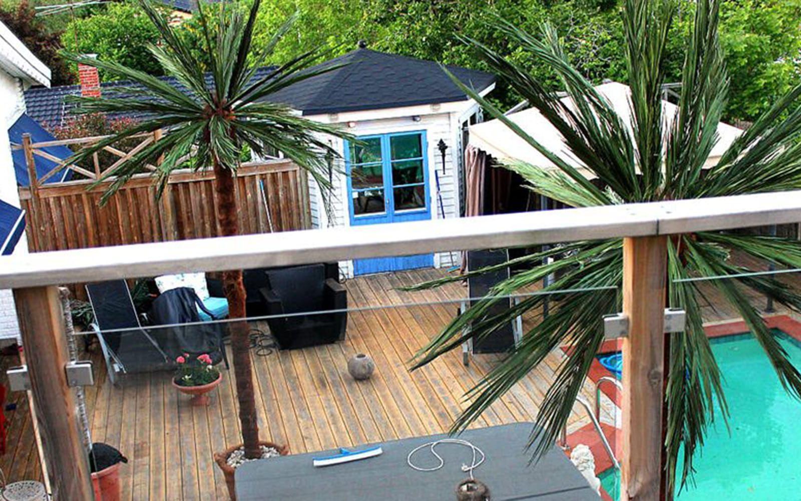 Enligt mäklaren är det en spanskinspirerad poolvilla – och visst ger de två palmerna lite medelhavsfeeling? Foto: SthlmFast
