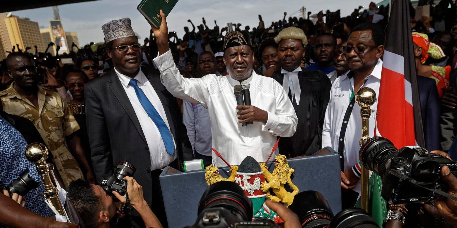 Oppositionspolitikern Miguna Miguna, här till vänster om oppositionsledaren Raila Odinga (i mitten) vid ceremonin i Nairobi.