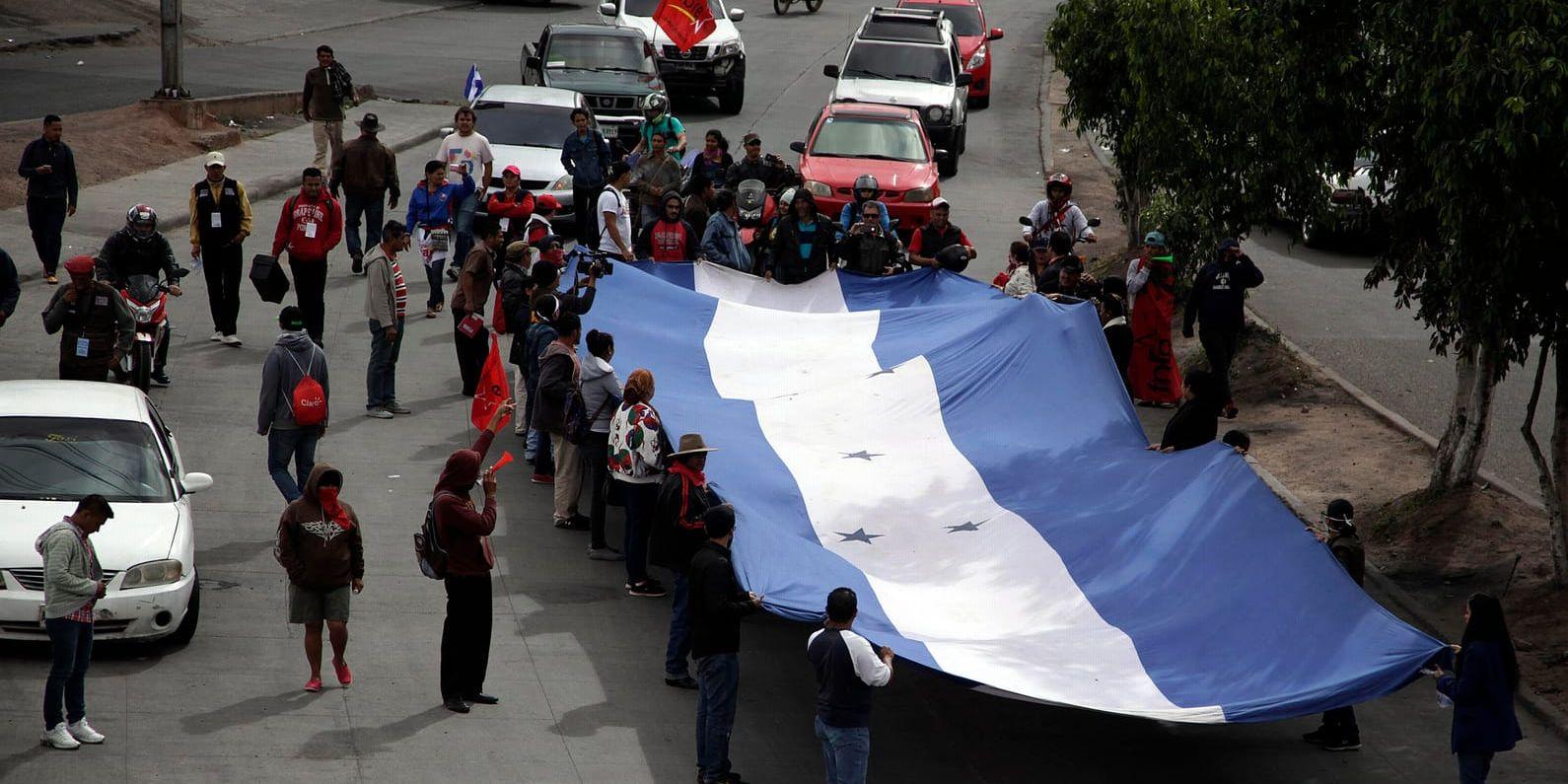Salvador Nasralla-anhängare försöker stänga av en gata i Tegucigalpa med en flagga. Arkivbild.