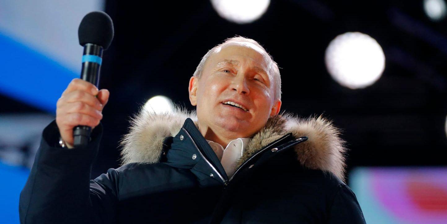 Rysslands president Vladimir Putin talar från en scen i centrala Moskva efter att ha vunnit valet på söndagen.