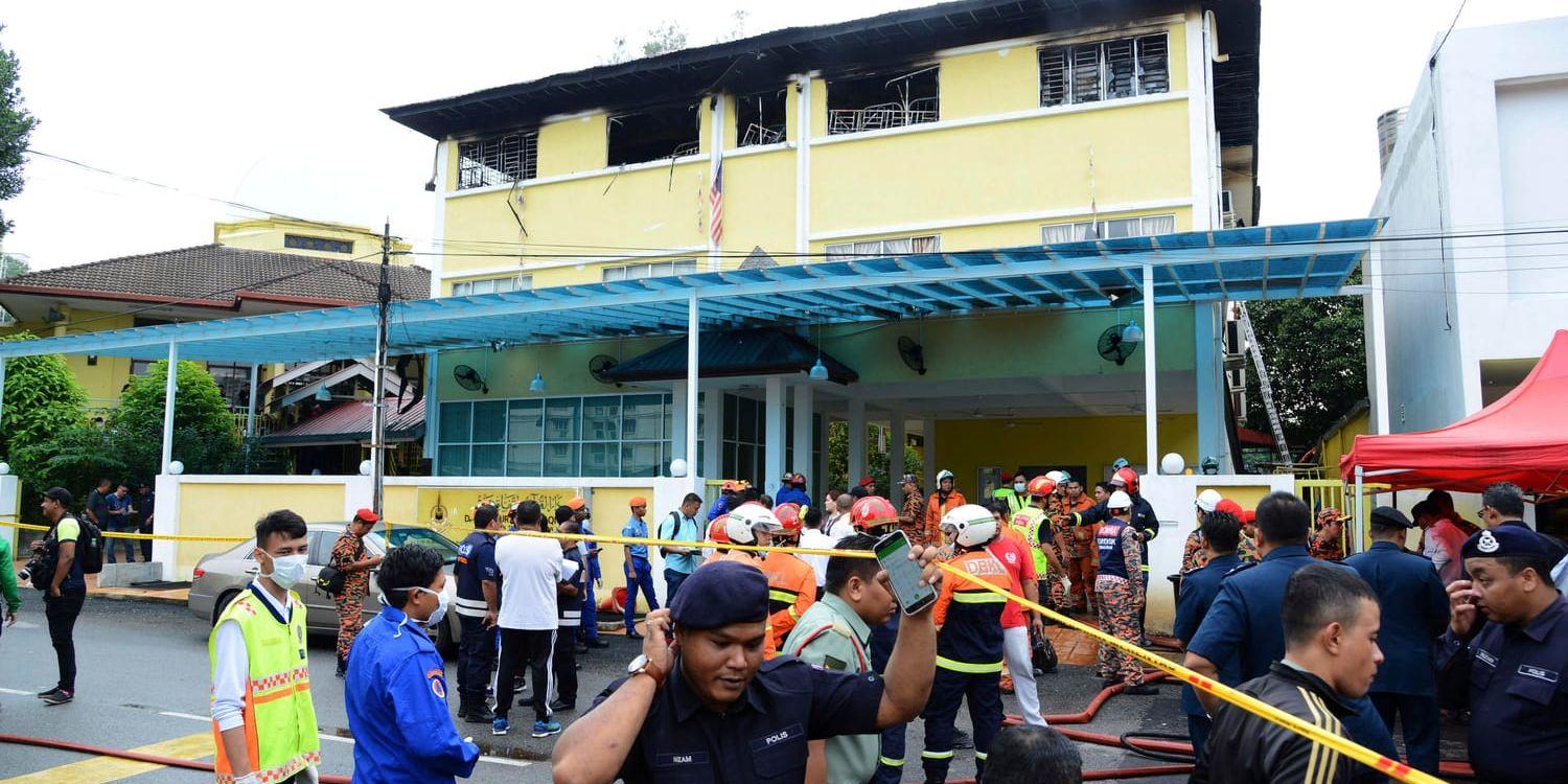 Polis och räddningspersonal utanför den eldhärjade skolan i Kuala Lumpur.