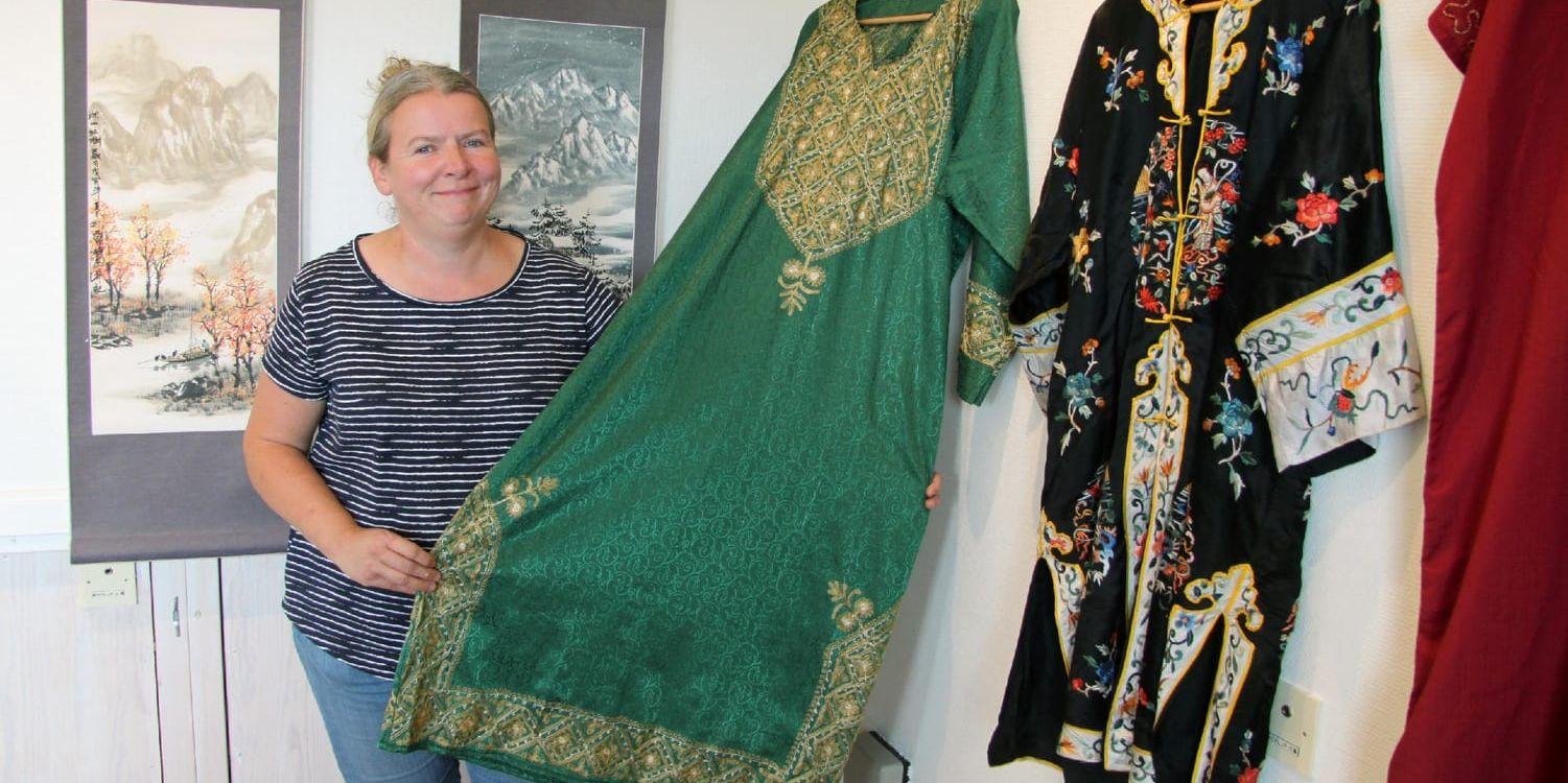 Indiskt grönt. IT-bibliotekarie Helena Sandström håller upp ett indiskt klädesplagg som ingår i utställningen.