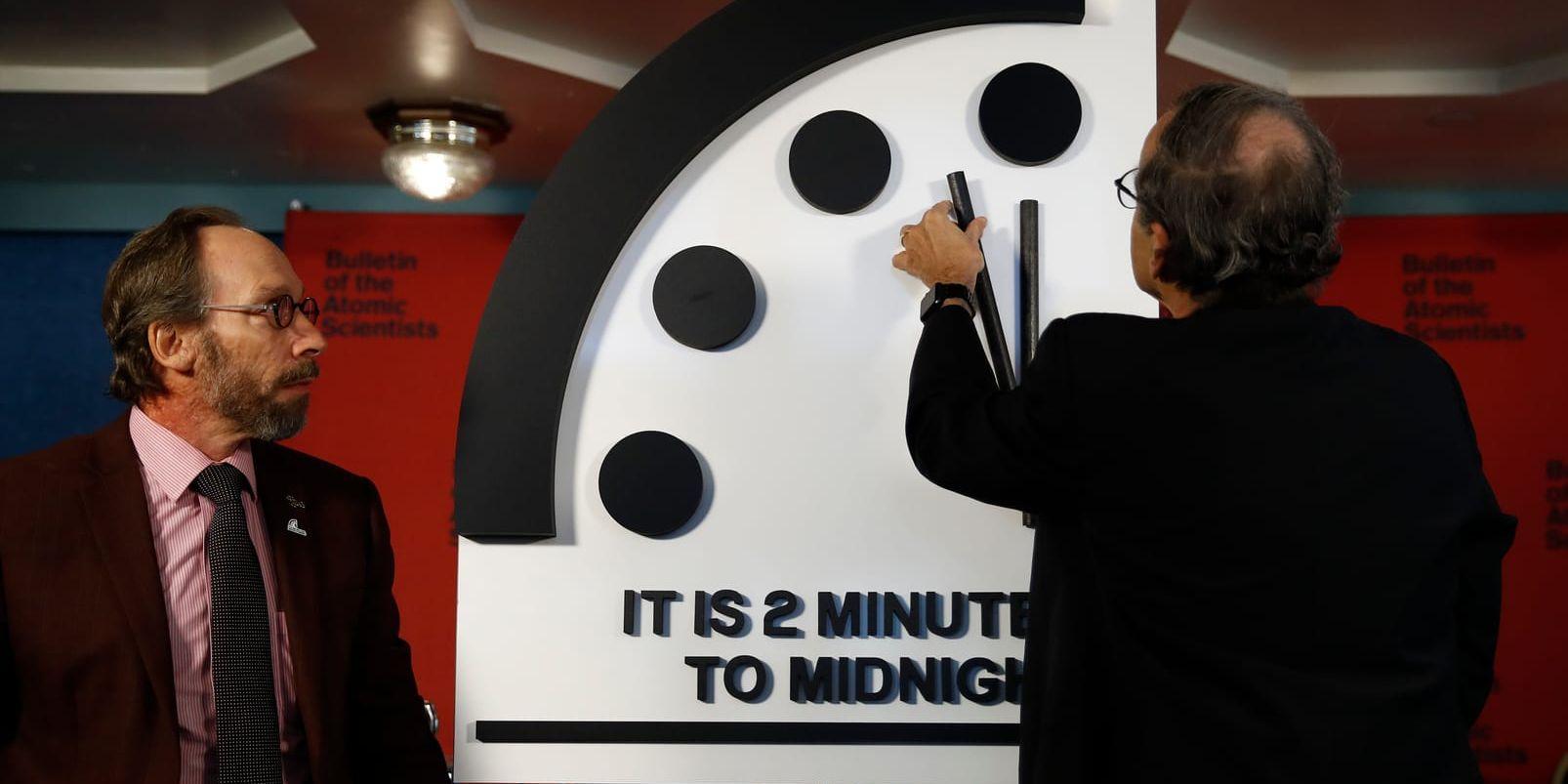 Vrids fram. Fysiker Lawrence Krauss ser på när hans kollega Robert Rosner justerar domedagsklockan.
