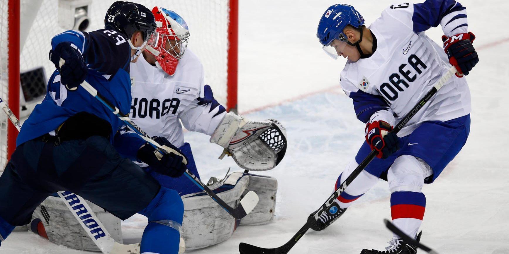 Sydkoreas Kim Won-Jun (nummer 6) och målvakt Matt Dalton (1) mot Finlands Joonas Kemppainen (23) i åttondelsfinalen i herrarnas OS-ishockey.