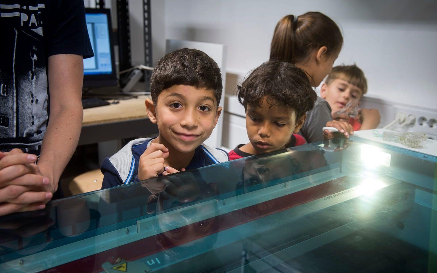NYFIKNA. Barnen är nyfikna på att se resultatet efter att laserskrivaren har gjort sitt jobb. Bild: Jörgen Alström
