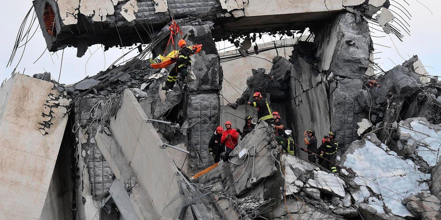 Brandkåren räddar en person från bråten efter den kollapsade Morandi-bron i Genua i Italien.