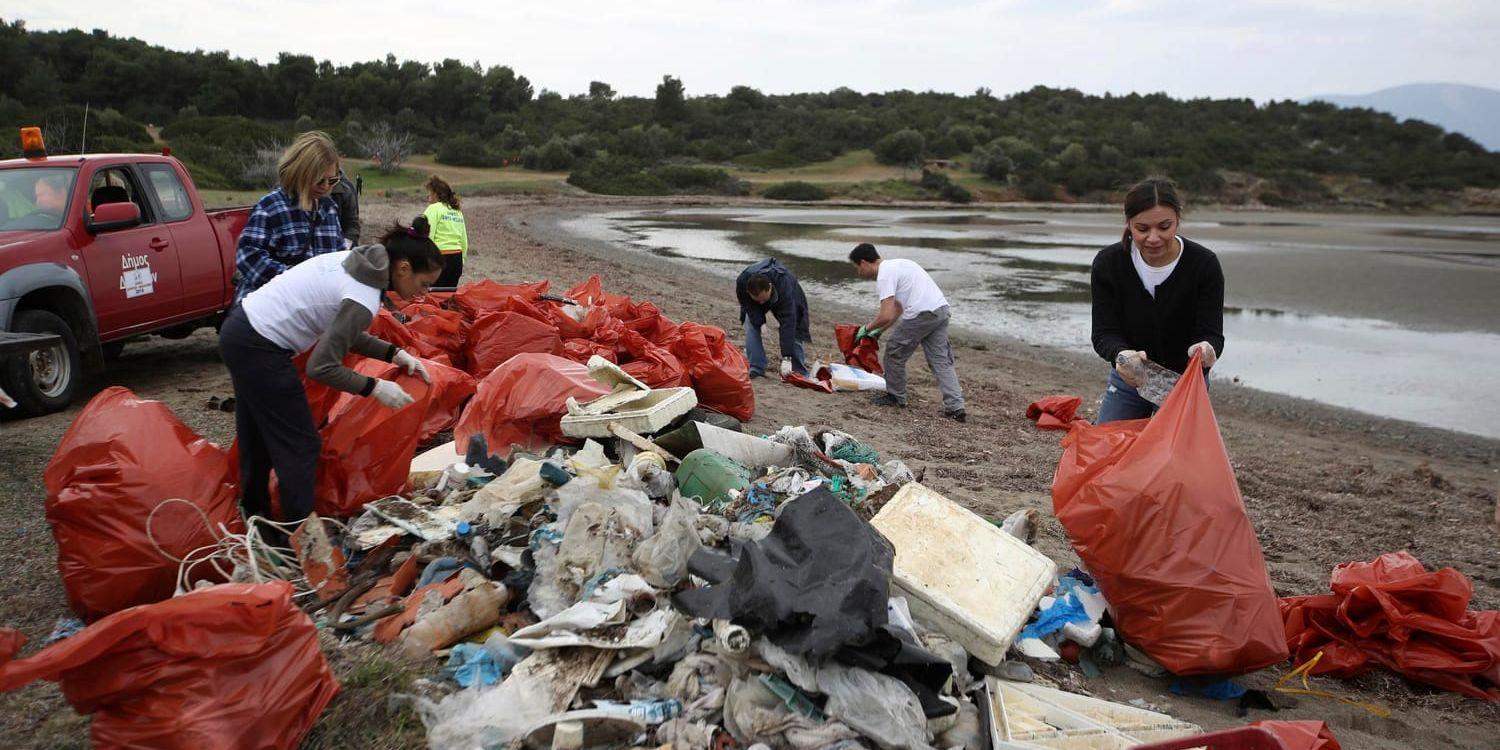 EU:s hårdare regler mot engångsplast är framför allt till för att minska mängden plast i havet och på stränder. På arkivfotot från februari samlar frivilliga in sopor på en strand på ön Evvia, nordost om Aten. Arkivbild.