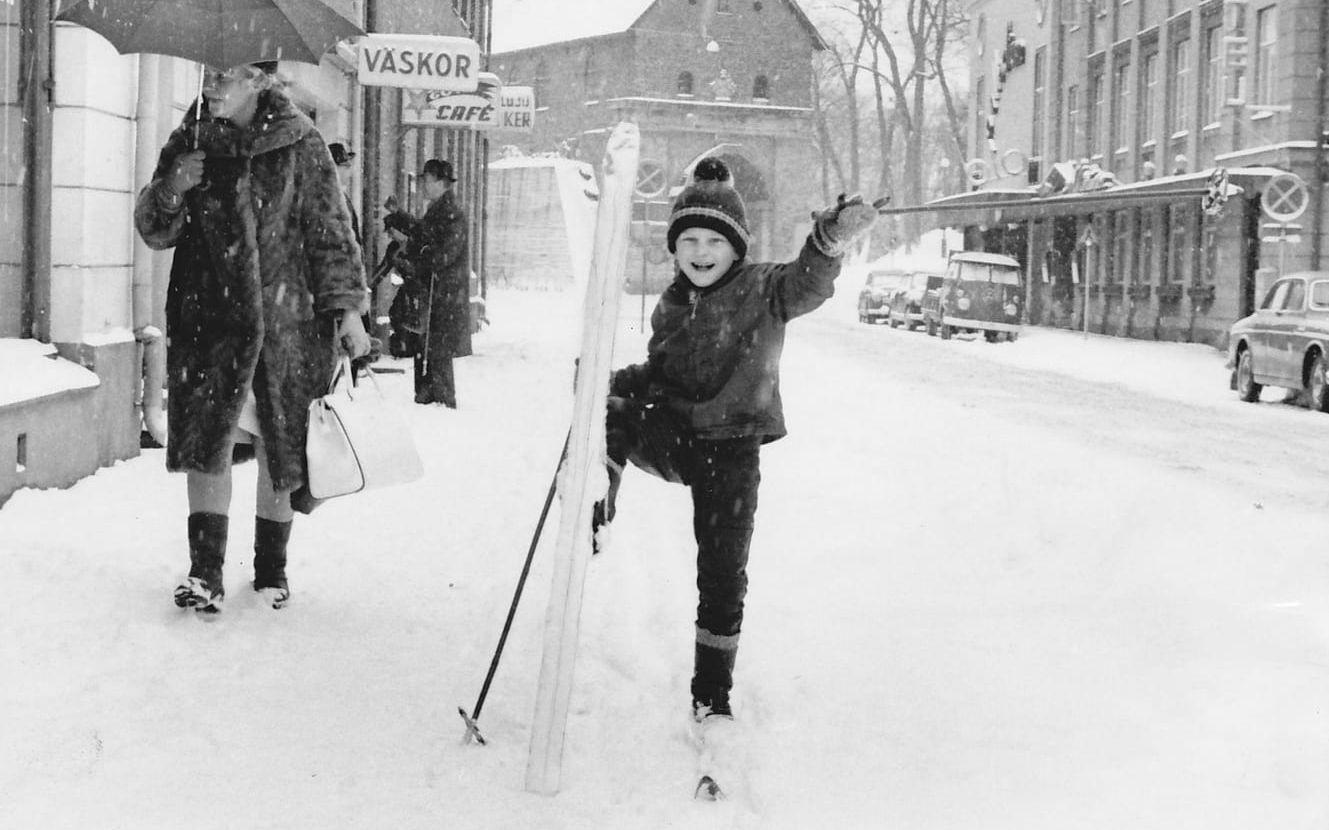 Det har plötsligt snöat i april 1966 och Toni ”Otto” Ottosson tar en bild av sin son Roger, som åker skidor på Storgatan. Gatan är vid den tiden trafikerad av bilar som kör på vänster sida. Bild: Toni Ottosson