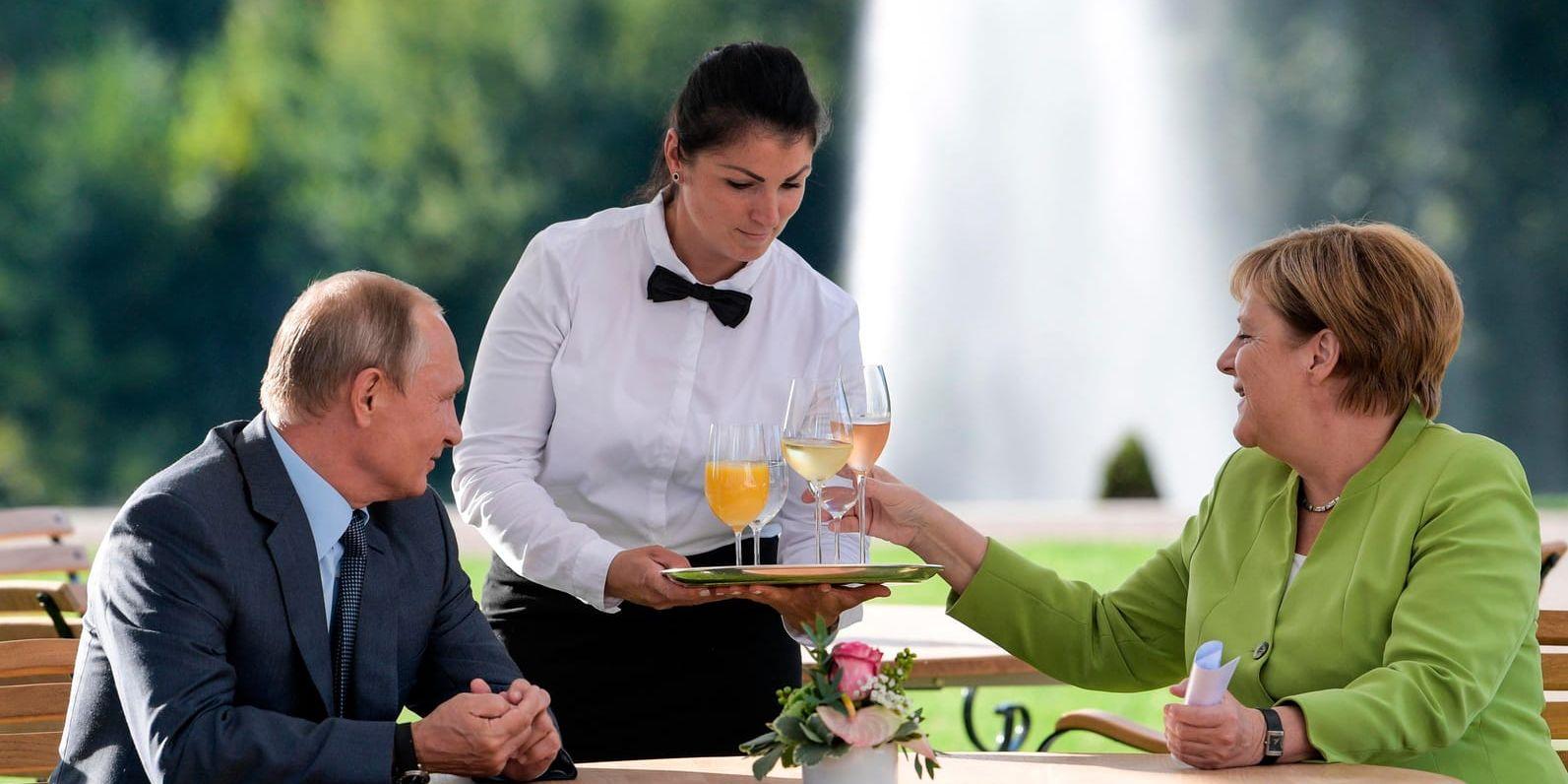Vladimir Putin och Angela Merkel serveras förfriskningar under mötet vid slottet Meseberg utanför Berlin.
