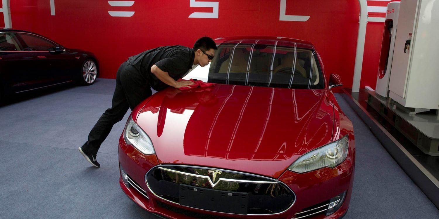 En medarbetare putsar en Tesla-bil inför leverans till kund i Peking.