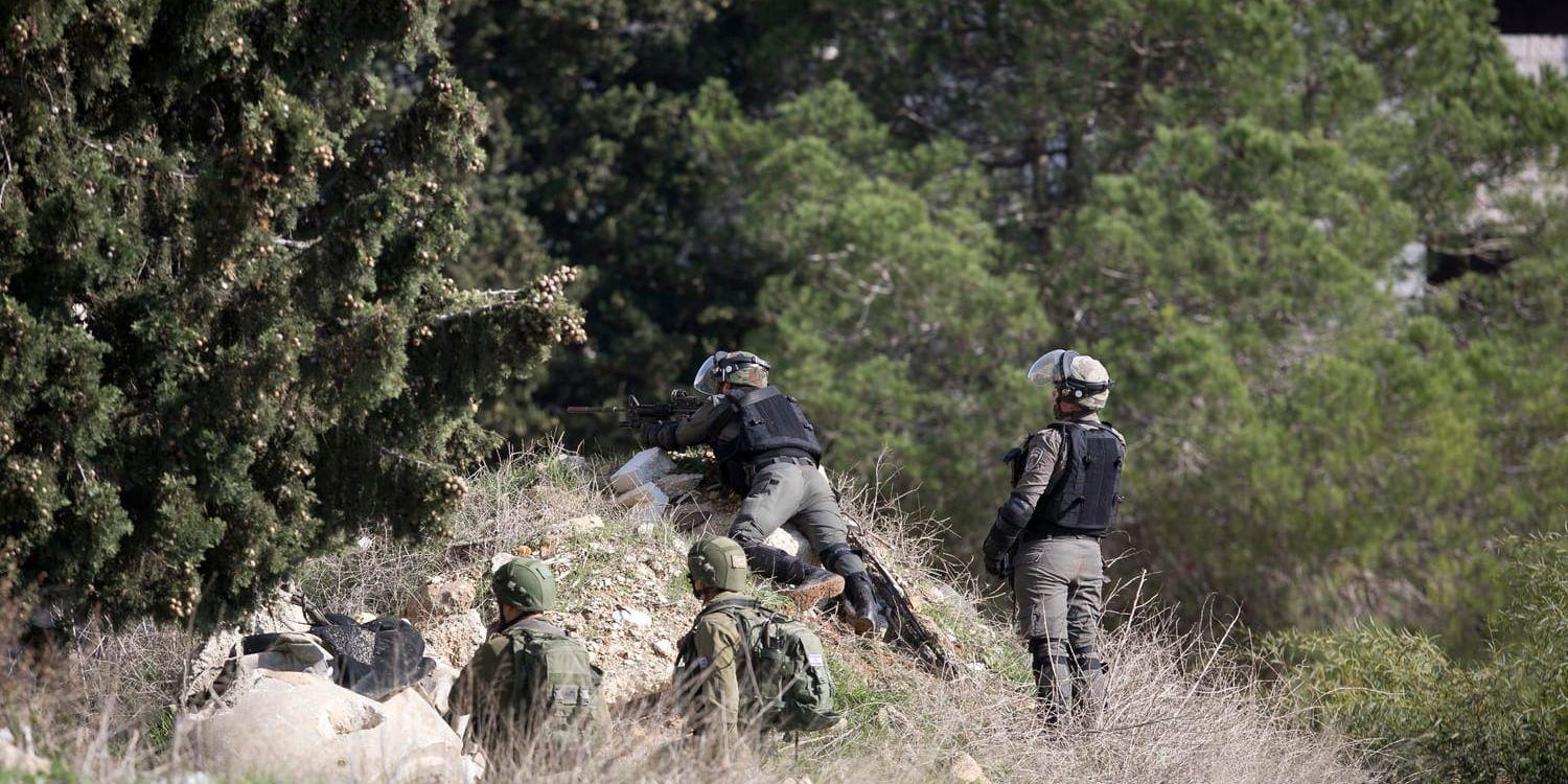 Israeliska soldater söker efter gärningsmännen som låg bakom en skottlossning vid en busshållplats nära bosättningen Ofra på den ockuperade Västbanken.