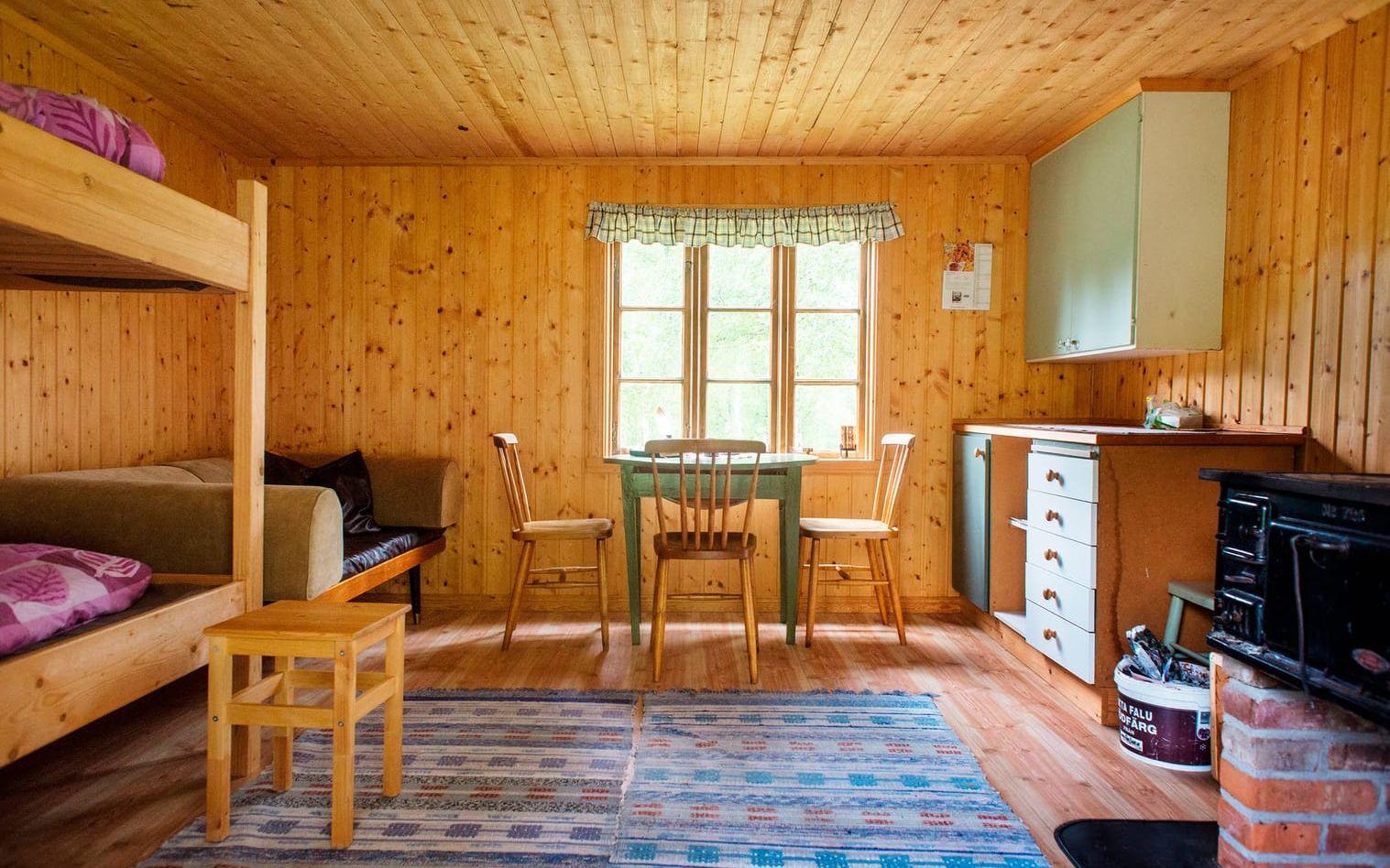 Stugan är inredd med en våningssäng, soffa, bord, stolar och en kamin. Moa Karlberg beskriver stugan som ny och fräsch. Bild: Moa Karlberg
