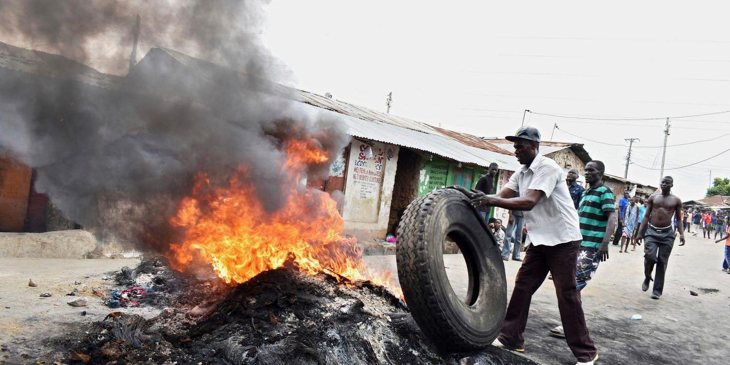 En oppositionsanhängare bränner däck vid en demonstration i Mombasa.