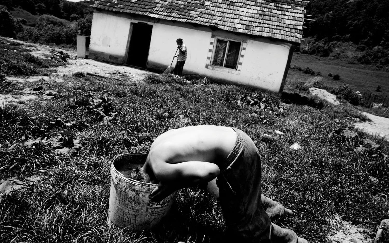 En ung man i den fattiga byn Apold i rumänska Transylvanien har fyllt en hink för att tvätta håret. Bild: Åke Ericson