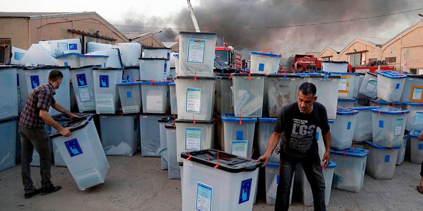 Irakiska valarbetare räddar valurnor från en brand i en byggnad i Bagdad tidigare i juni.