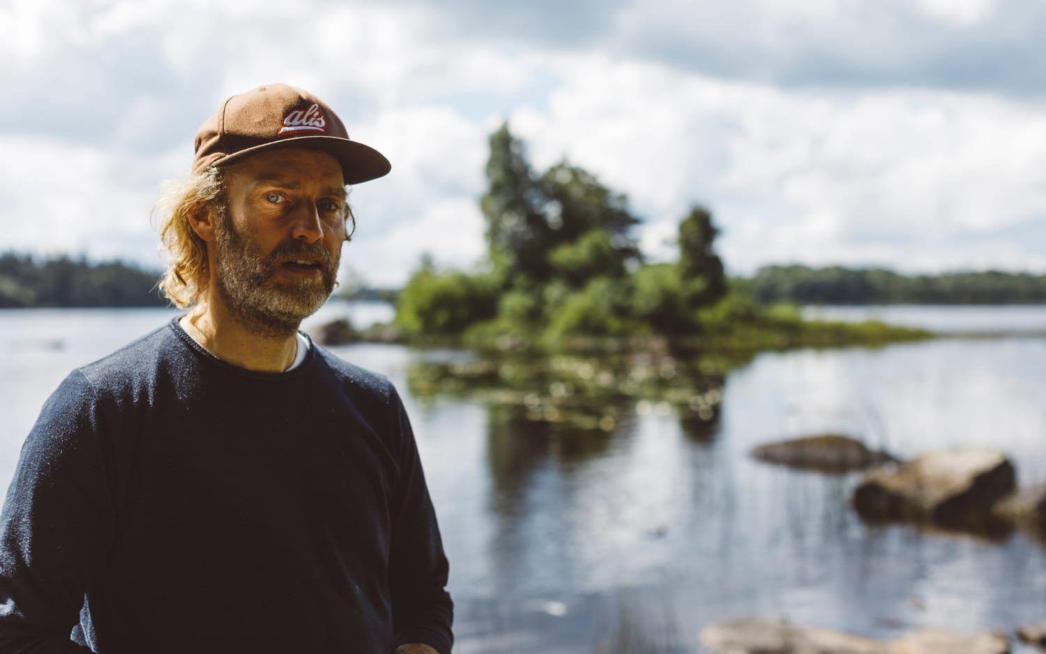 Flemming ser ut över naturen – i bakgrunden den lilla ön vars kontur har fått stå modell för Stedsans in the Woods nya logga. Bild: Anders Andersson