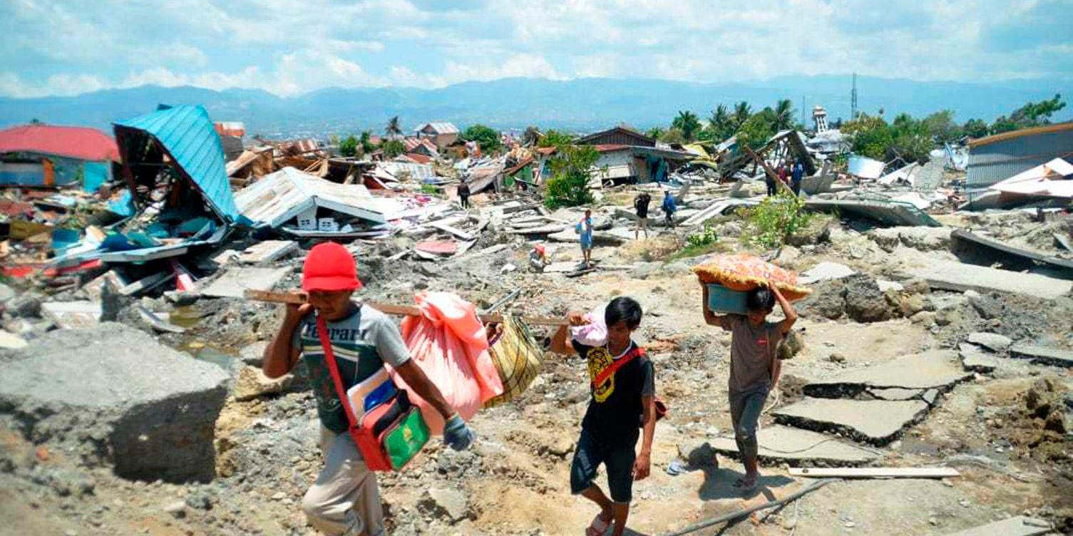 Barn som bär undan tillhörigheter i den skalv- och tsunamidrabbade staden Palu på Sulawesi i Indonesien.