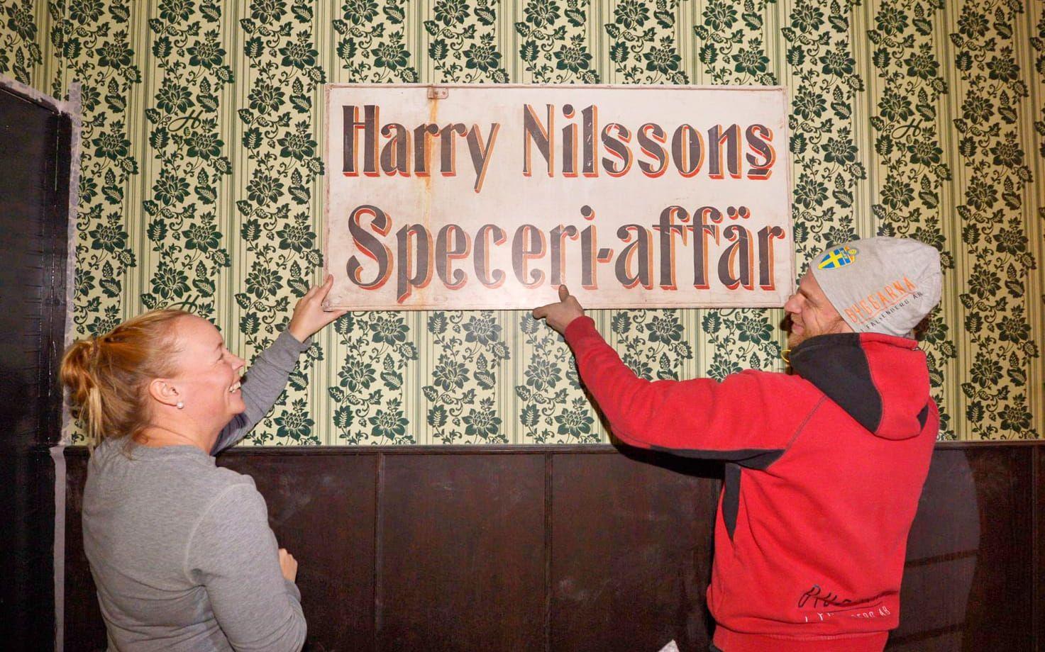 Glömmer inte rötterna. En skylt från grundaren Harry Nilssons gamla affär får ta plats på väggen. Bild: Jari Välitalo