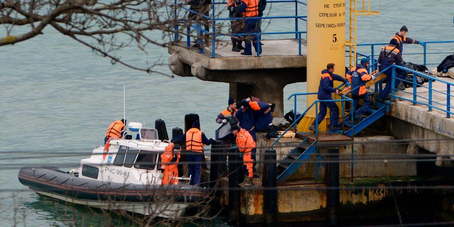 Räddningsarbetare för i land kvarlevor efter kraschen i Svarta havet.