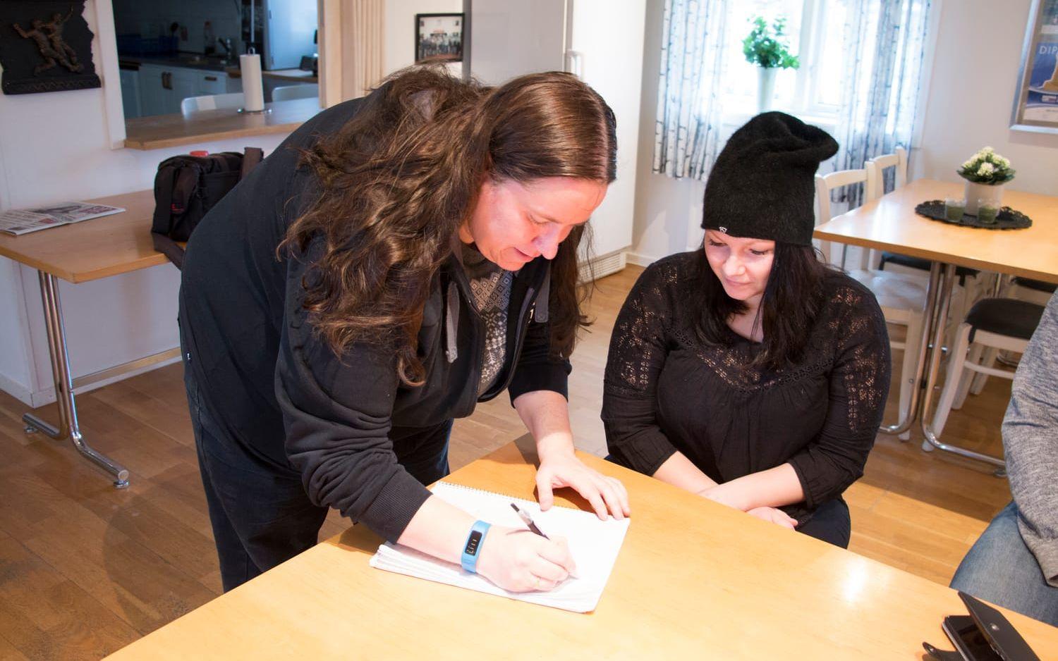 Kritar på. Byalagets ordförande Anna Hjort skriver på Cathrine Mellbergs namninsamling.