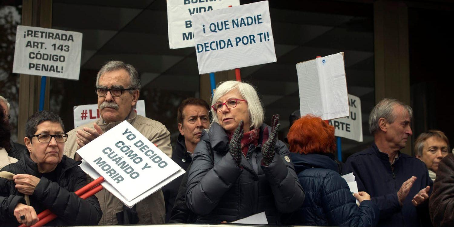 Människor utanför en domstol i Madrid som demonstrerar för en legalisering av dödshjälp.