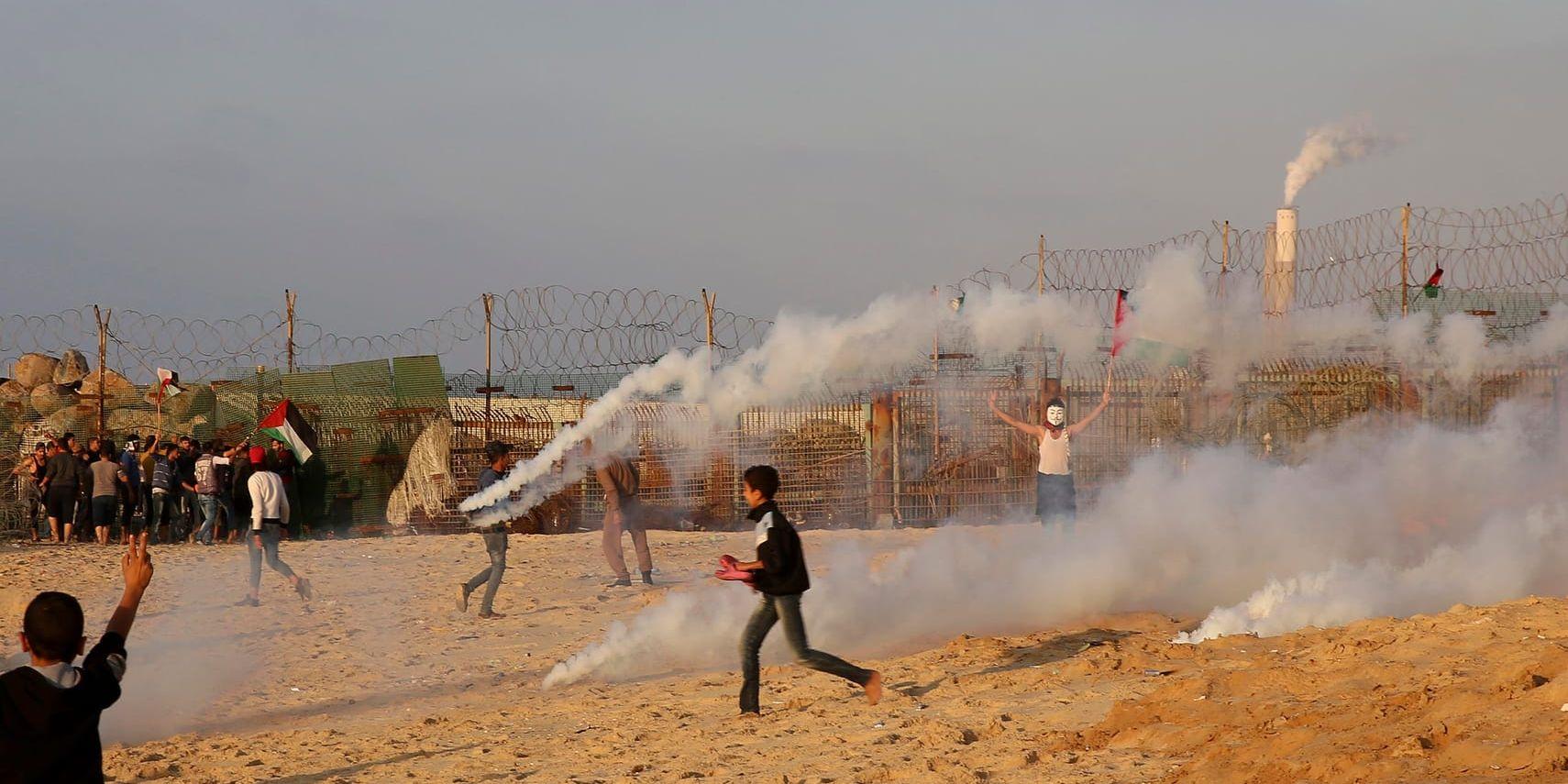 Demonstranter flyr undan tårgas vid en demonstration vid gränsstängslet mellan Israel och Gaza. Arkivbild.