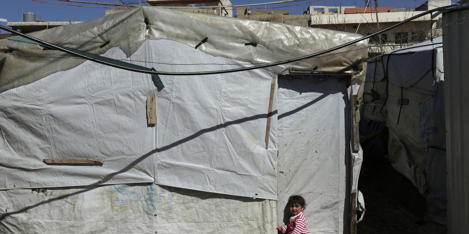 Ett barn utanför ett tält i ett läger för syriska flyktingar i staden Tripoli i norra Libanon. Arkivbild. 