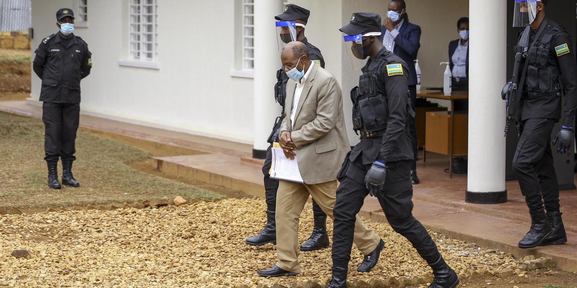 Paul Rusesabagina leds ut från rätten i handfängsel, efter måndagens delgivning av formella anklagelsepunkter.