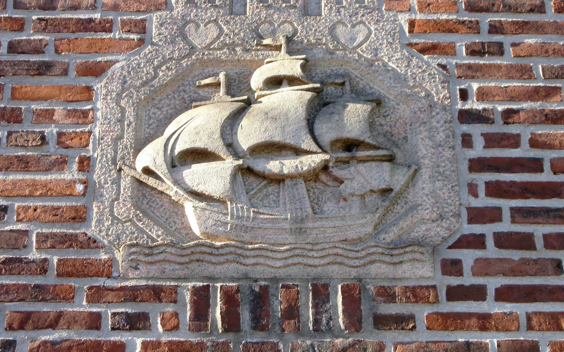 Ett stenskepp för fulla segel pryder Sparbankens entré mot Hamngatan.