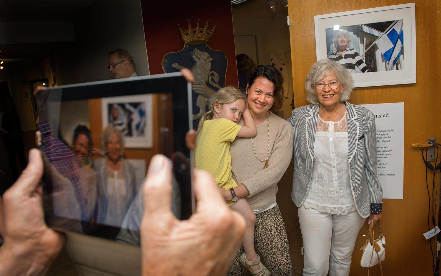 Vernissage. Nanny Ohlsson kom som krigsbarn från Finland till Halmstad 1942. Här står hon med barnbarnet Sara Gustafsson och barnbarnsbarnet Edith. Foto: Johan Persson