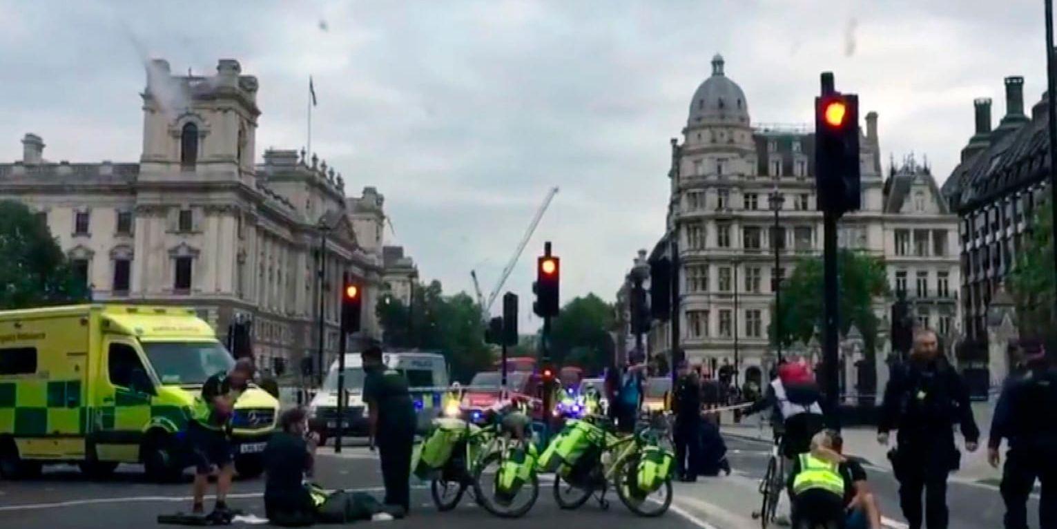 Ambulans och säkerhetspersonal utanför det brittiska parlamentet i London sedan en bil kraschat in i en säkerhetsbarriär.
