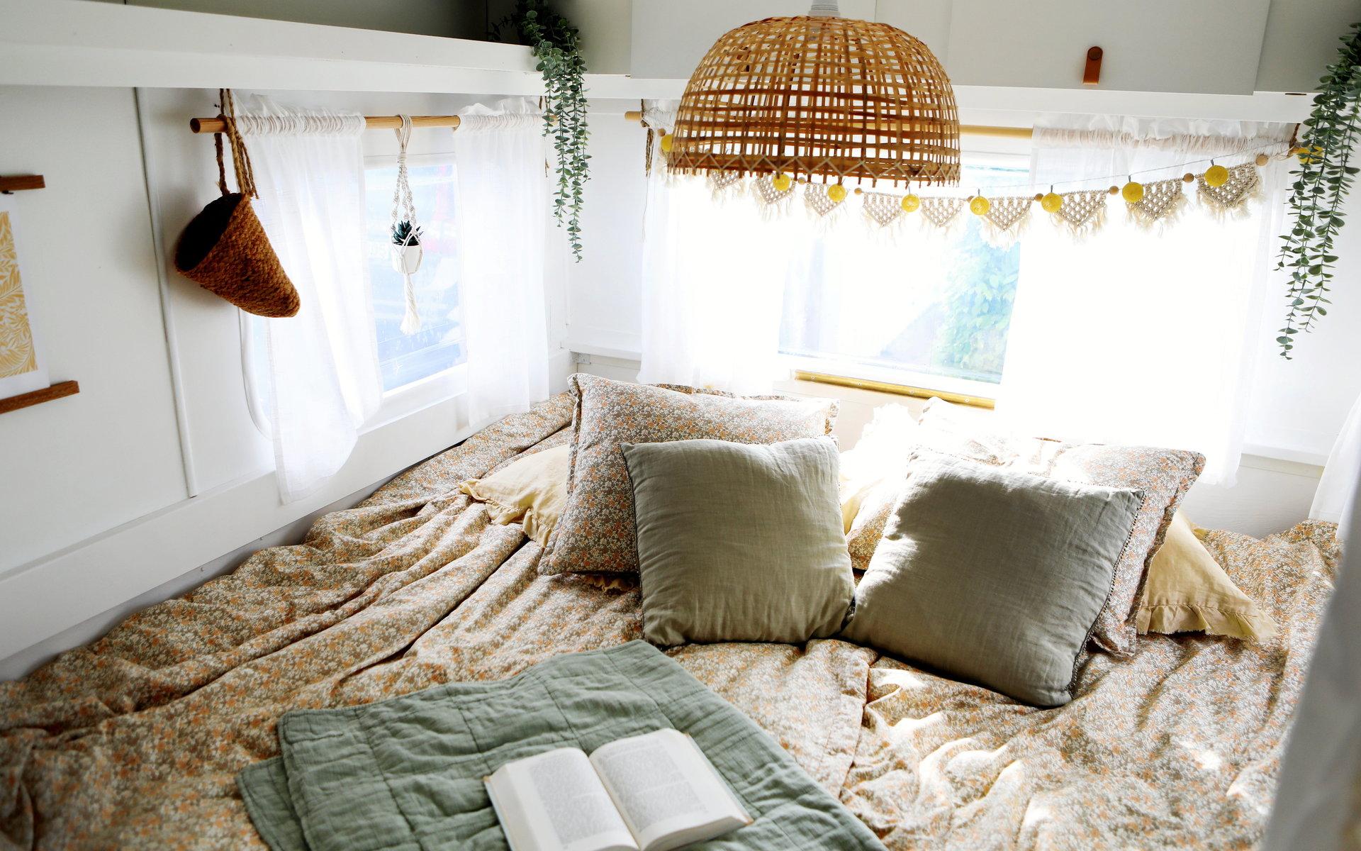 Lampan över sängen matchar naturfärgerna i mattor och textilier.