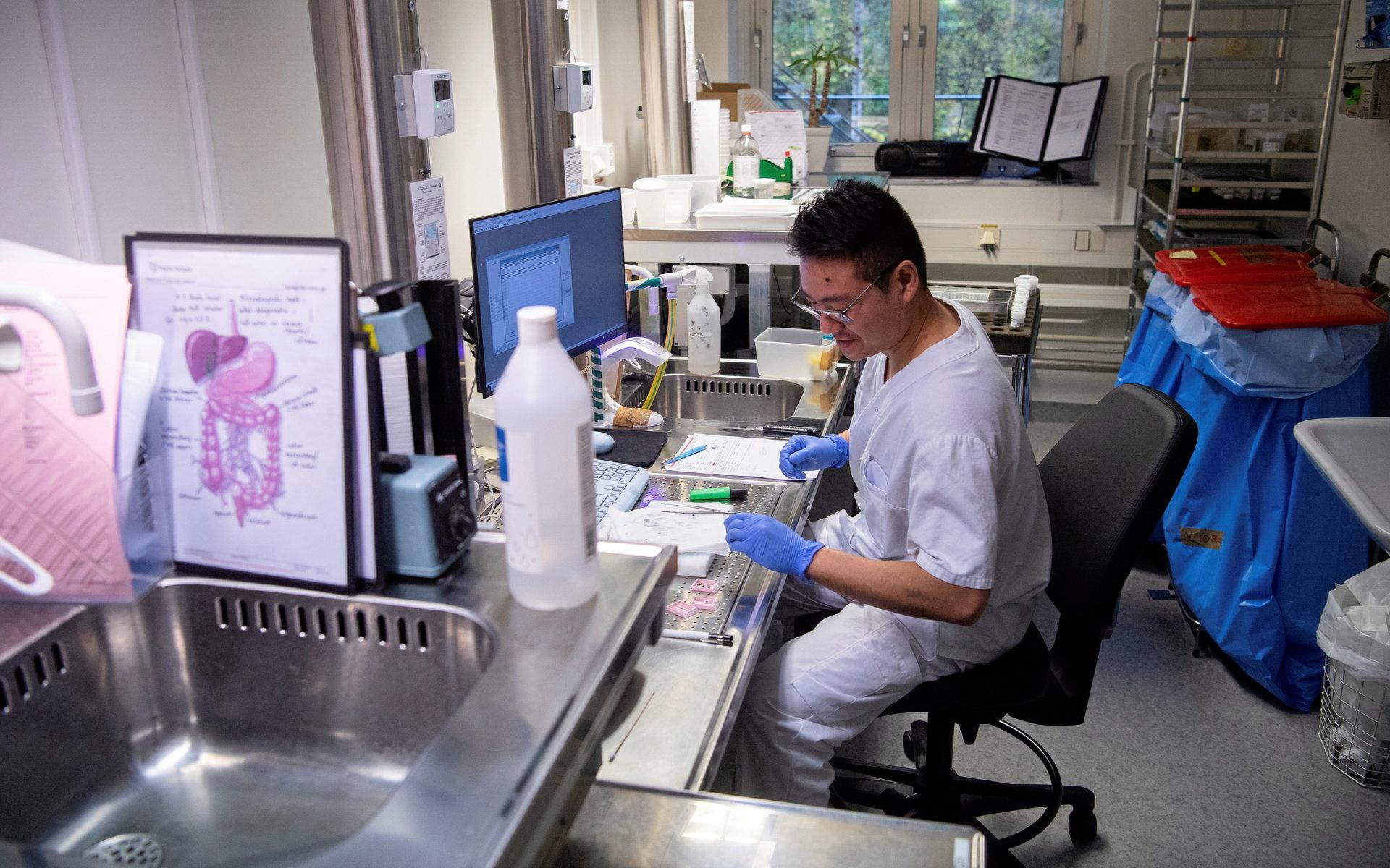 Läkare skär ut större och mer avancerade preparat medan andra kan delegeras till biomedicinska analytiker. Som hud som Manh Nguyen jobbar med här.