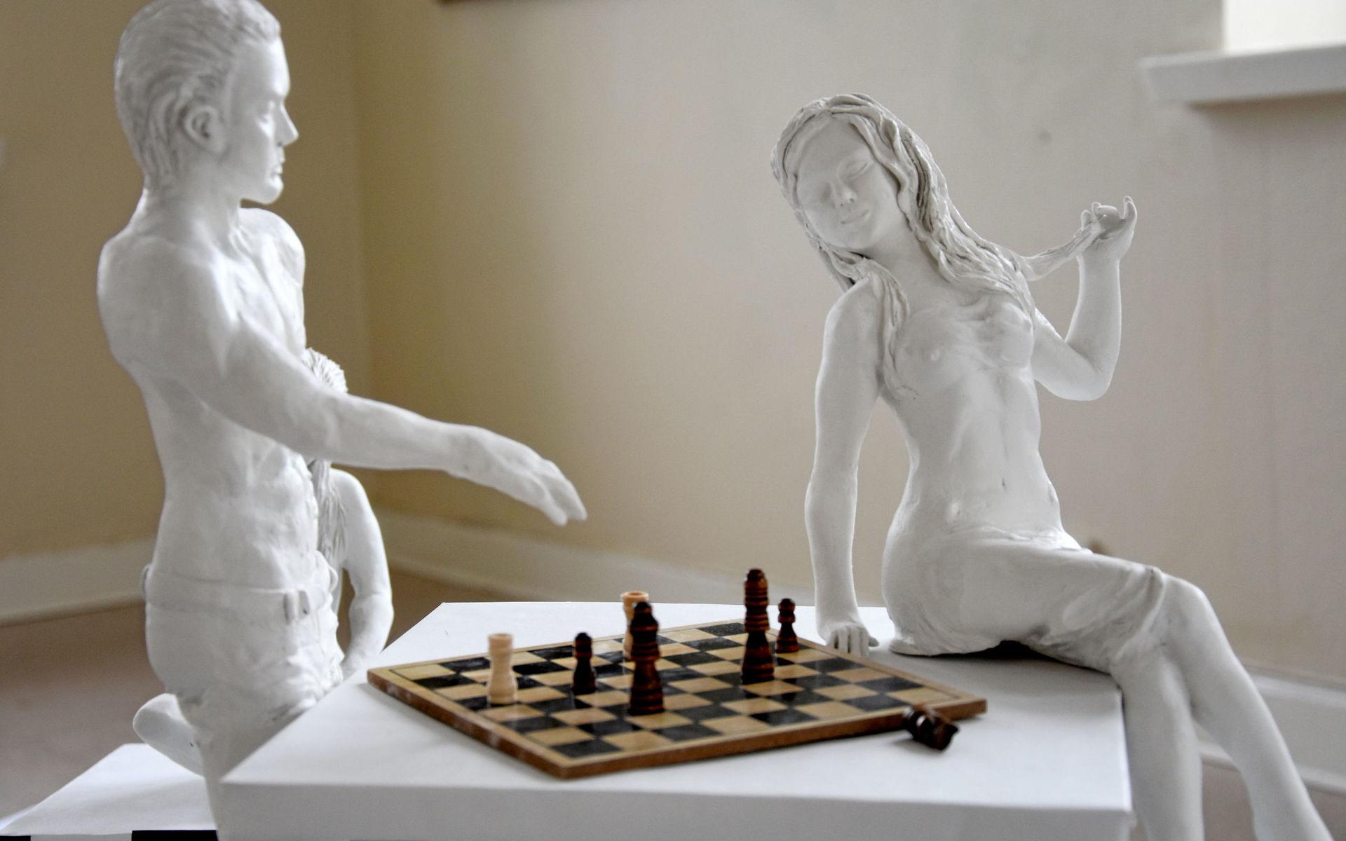 I konstverket &quot;Hon och han&quot; har Olga Plotnikova skapat laddade möten mellan man och kvinna runt ett parti schack. Skulpturer i modelleringsmassa. 