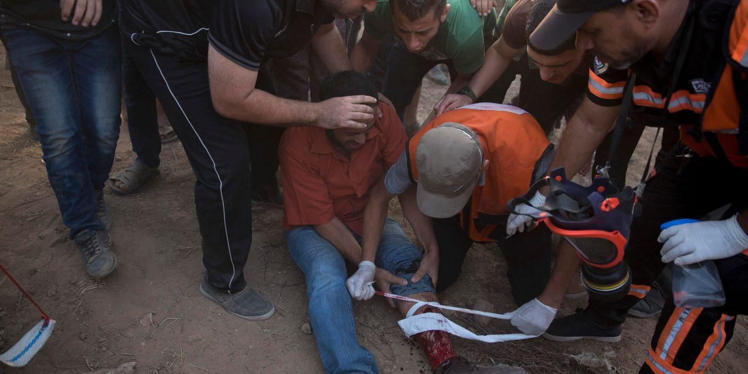 En Gazabo får hjälp efter att ha skjutits av israeliska trupper under demonstrationer vid gränsen mellan Gaza och Israel på fredagen.