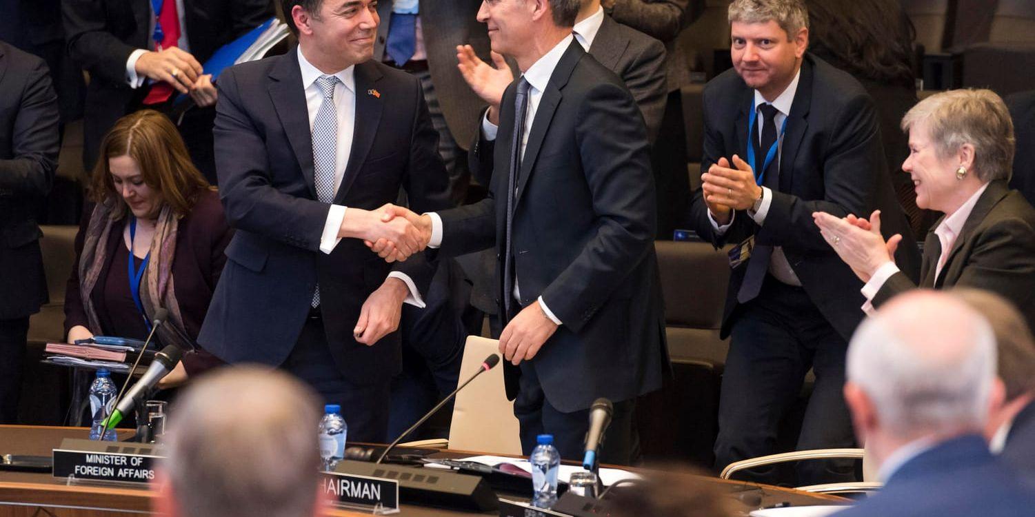Makedoniens utrikesminister Nikola Dimitrov och Natos generalsekreterare Jens Stoltenberg skakar hand när avtalet skrivits under.