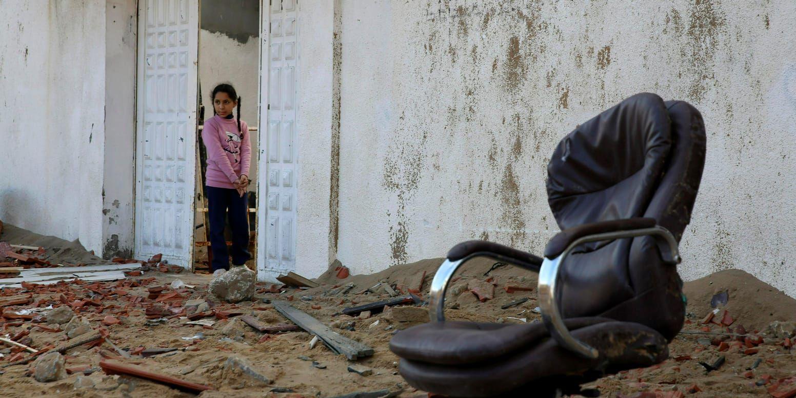 En palestinsk flicka tittar ut från familjens hus på tisdagen mot rester av Hamasledaren Ismail Haniyas högkvarter i Gazaremsan.