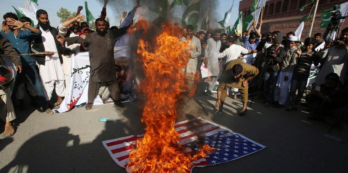 USA:s hot om indraget bistånd har väckt ilska i Pakistan. Här bränns en amerikansk flagga i Karachi.