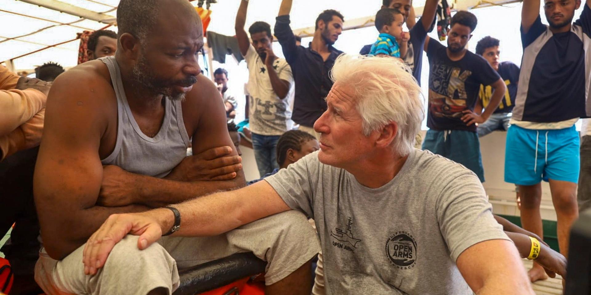 Skådespelaren Richard Gere pratar med en migrant ombord fartyget Open Arms 2019.